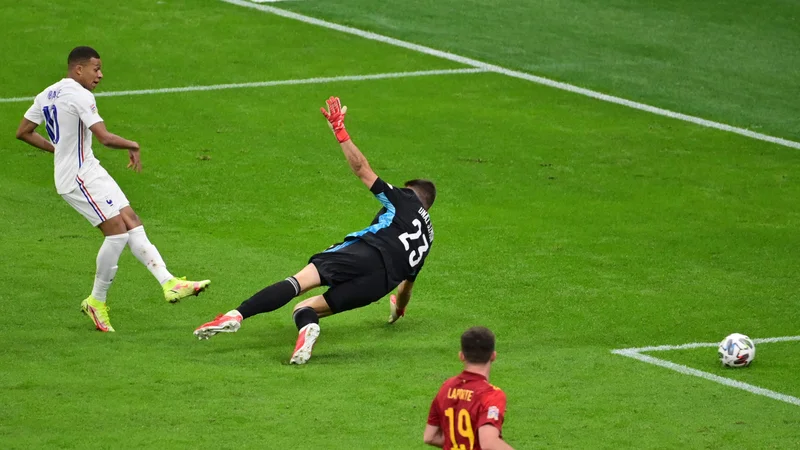 Fotografija: Kylian Mbappe je matiral španskega vratarja Unaia Simona, toda njegov gol bo povzročil tudi nekaj konkretnih polemik, saj je gol dosegel iz sporne akcije. V trenutku podaje je bil v nedovoljenem položaju. FOTO: Miguel Medina/AFP