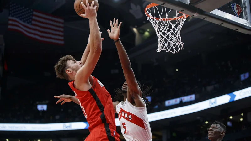 Fotografija: Houstonov turški center Alperen Sengun prodira ob Preciousu Achiuwi na obračunu v dvorani Scotiabank Arena. FOTO: Cole Burston/AFP