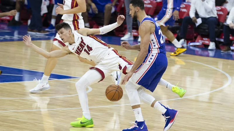 Fotografija: Ben Simmons (desno) prodira ob Tylerju Herru na tekmi z Miami Heat. FOTO: Mitchell Leff/AFP