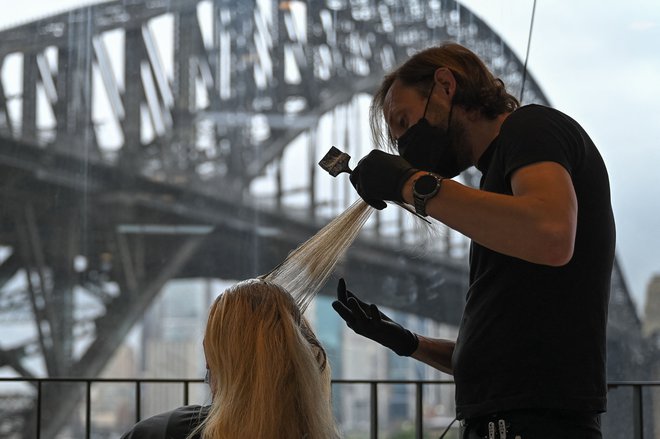 Ženska v frizerskem salonu blizu pristanišča v Sydneyju po koncu lockdowna, ki je trajal 106 dni. FOTO: Steven Saphore/AFP
