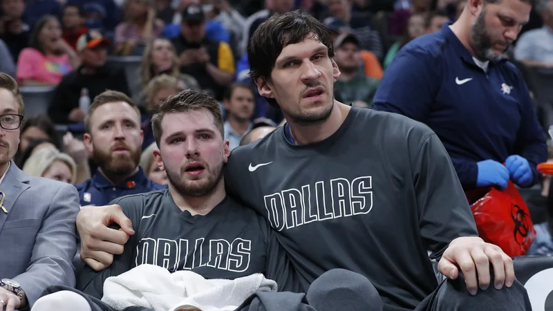 Fotografija: Luka Dončić v medvedjem objemu Bobana Marjanovića. FOTO: USA Today Sports
