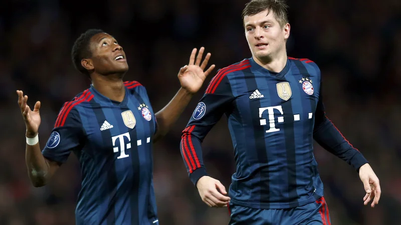 Fotografija: David Alaba (levo) in Toni Kroos se še kot člana Bayerna veselita gola na tekmi lige prvakov z Arsenalom v Londonu. FOTO: Eddie Keogh/Reuters