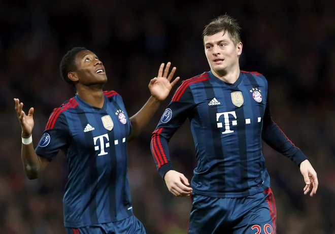 David Alaba (levo) in Toni Kroos se še kot člana Bayerna veselita gola na tekmi lige prvakov z Arsenalom v Londonu. FOTO: Eddie Keogh/Reuters
