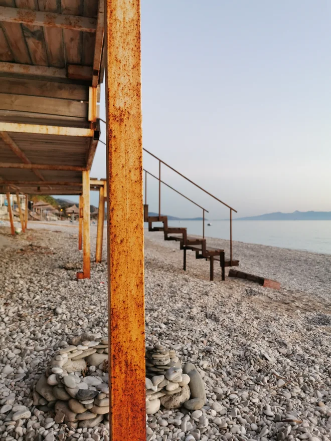 Prazna plaža v mestecu Borsh s pogledom na grški otok Krf. FOTO: Lucijan Zalokar
