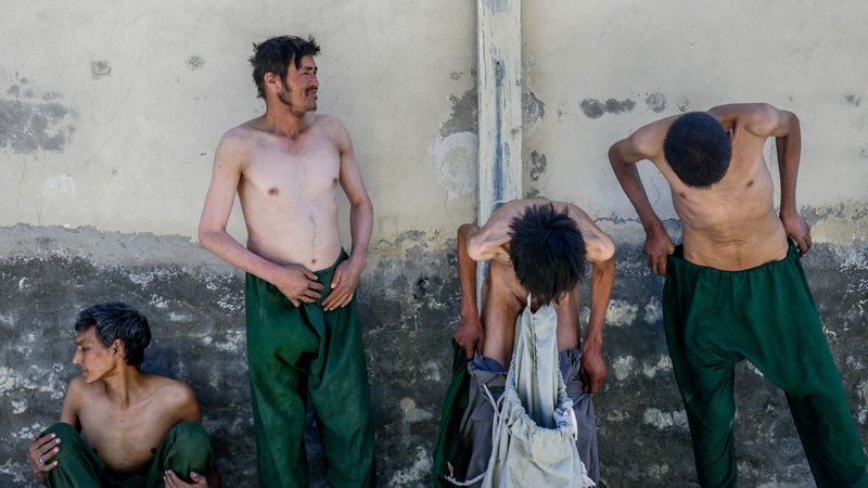 Fotografija: Odvisniki od drog se ob prihodu v bolnišnico Avicenna v Kabulu preoblačijo. Z obritimi glavami, prevelikimi oblačili in prestrašenim pogledom, so jih talibani prisilno zaprli za 45 dni med štiri stene. FOTO: Bulent Kilic/Afp
