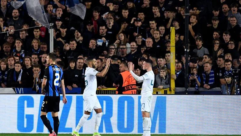 Fotografija: Phil Foden (desno) in Riyad Mahrez proslavljata pred navijači Bruggea. FOTO: John Thys/AFP
