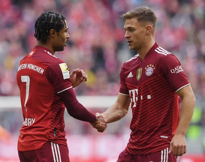 Joshua Kimmich (desno) in Serge Gnabry med zadnjo prvenstveno tekmo proti Hoffenheimu. Bavarci so zaradi okužbe z novim koronavirusom sicer sredi tedna ostali brez trenerja Juliana Nagelsmanna, ki je moral v samoosamitev. FOTO: Christof Stache/AFP
