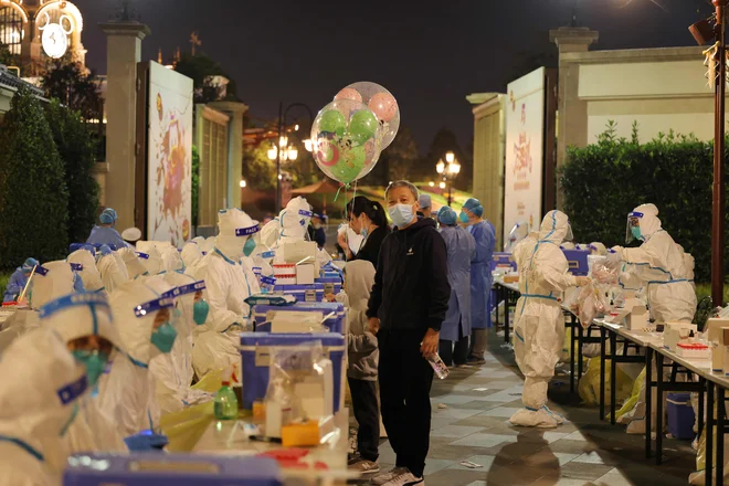 Noč čarovnic je bila v šanghajskem Disneylandu prepričljiva, ko so se med obiskovalci pojavili posamezniki v belih skafandrih. FOTO: AFP