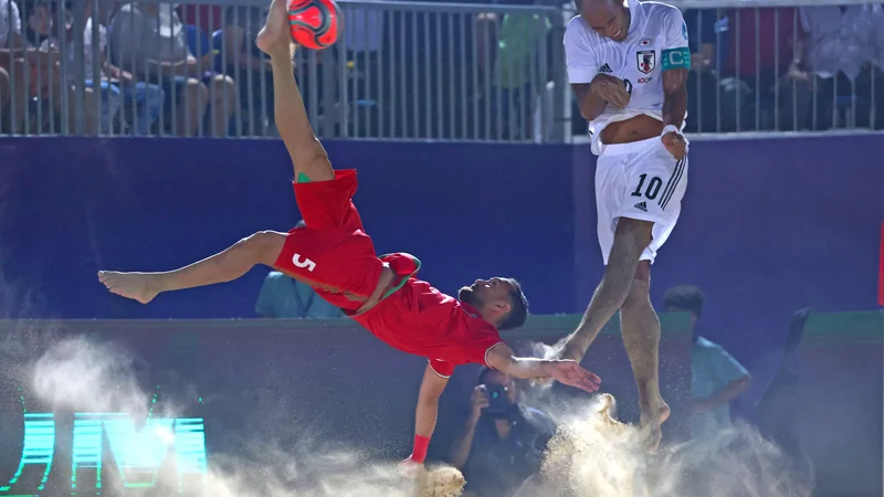Fotografija: Utrinek iz tekme Interkontinentalnega pokala v nogometu na mivki med Iranom in Japonsko v Dubaju. Na fotografiji je spektakularno streljal na gol Mohammad Moradi iz Irana. FOTO: Giuseppe Cacace/Afp