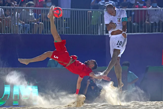 Utrinek iz tekme Interkontinentalnega pokala v nogometu na mivki med Iranom in Japonsko v Dubaju. Na fotografiji je spektakularno streljal na gol Mohammad Moradi iz Irana. FOTO: Giuseppe Cacace/Afp
