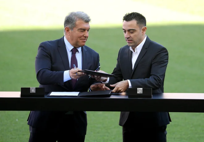 Xavi in predsednik Joan Laporta. FOTO: Albert Gea/Reuters
