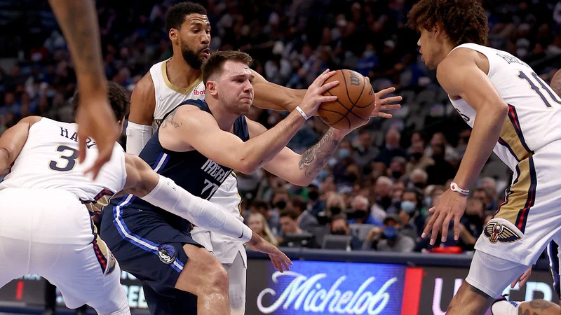 Fotografija: Luka Dončić prodira ob Joshu Hartu (št. 3), Garrettu Templi (41) in Jaxsonu Hayesu (10) v domačem American Airlines Centru. FOTO: Tom Pennington/AFP