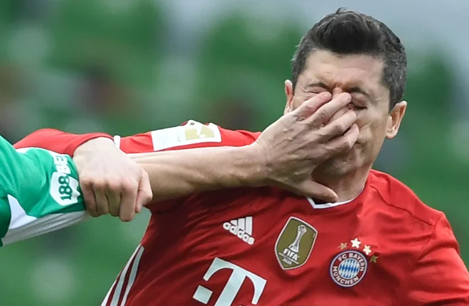 Marec 2021. Poljski napadalec Bayerna, Robert Lewandowski je v obraz dobil roko turškega branilca Bremna Omerja Topraka na nogometni tekmi nemške bundeslige med Werderjem Bremen in Bayernom. FOTO: Fabian Bimmer/Afp