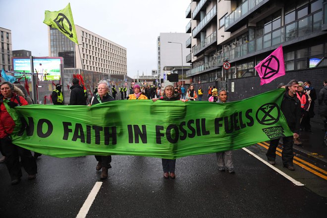 Protestniki v Glasgowu pozivajo k prenehanju uporabe fosilnih goriv. FOTO: Andy Buchanan/Afp
