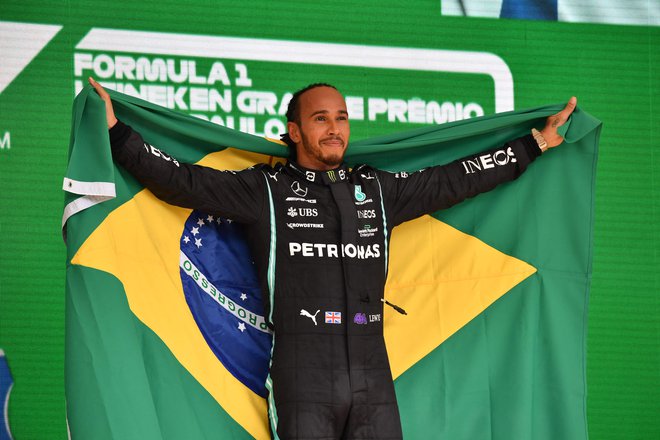 Lewis Hamilton je namesto britanske nosil brazilsko zastavo. FOTO: Nelson Almeida/AFP
