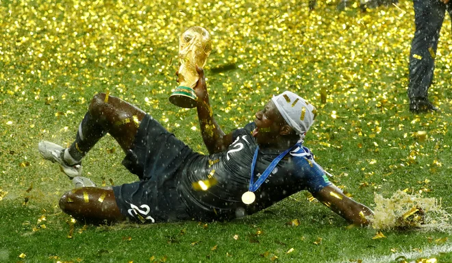 Benjamin Mendy s pokalom za naslov svetovnega prvaka. FOTO: Kai Pfaffenbach/Reuters
