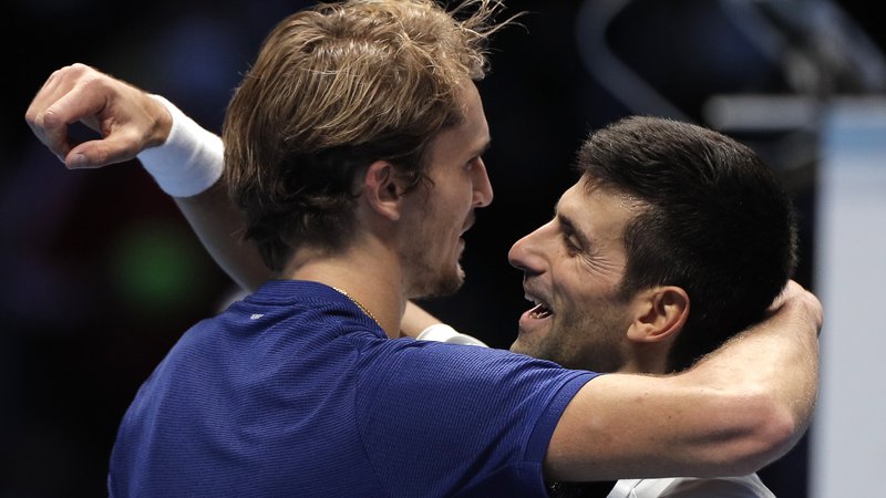 Fotografija: Alexander Zverev in Novak Đoković v objemu po epskem polfinalu v Torinu. FOTO: Guglielmo Mangiapane/Reuters
