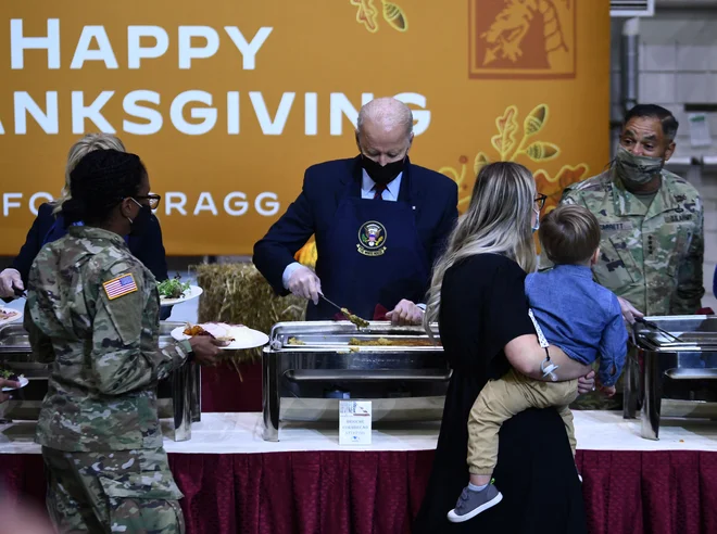 Ameriški predsednik Joe Biden streže s hrano vojakom v vojašnici Fort Bragg v Severni Karolini, pred prihajajočim praznikom zahvalnosti. FOTO: Brendan Smialowski/Afp