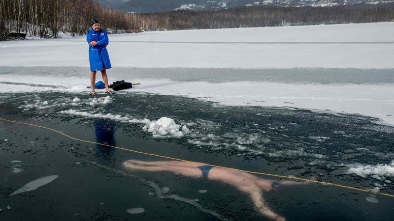 Fotografija: Češki potapljač David Vencl, posnet med plavanjem pod ledom februarja letos, ko se je pripravljal na 80-metrsko plavanje pod ledom. Foto Michal Cizek/AFP)
