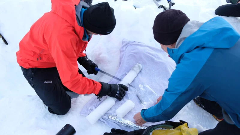 Fotografija: Testni preizkus novega ročnega lednega vrtalnika za odvzem globinskih vzorcev na snežišču v Vratih pod Triglavsko severno steno. FOTO: Andrej Štremfelj