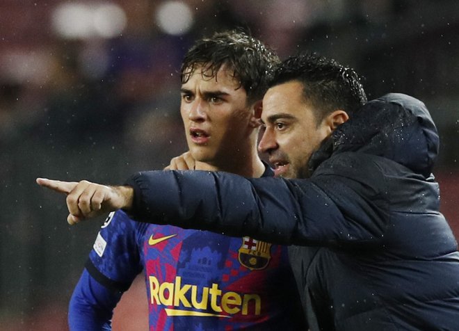 Xavi v pogovoru z Gavijem, šele 17-letnim upom Barcelone na sredini igrišča. FOTO: Albert Gea/Reuters
