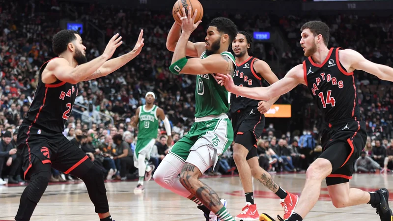 Fotografija: Jayson Tatum (z žogo) prodira pod koš ob Fredu VanVleetu in Sviju Mykhailiuku (št. 14) v drugem polčasu tekme v dvorani Scotiabank Arena. FOTO: Dan Hamilton/USA Today Sports