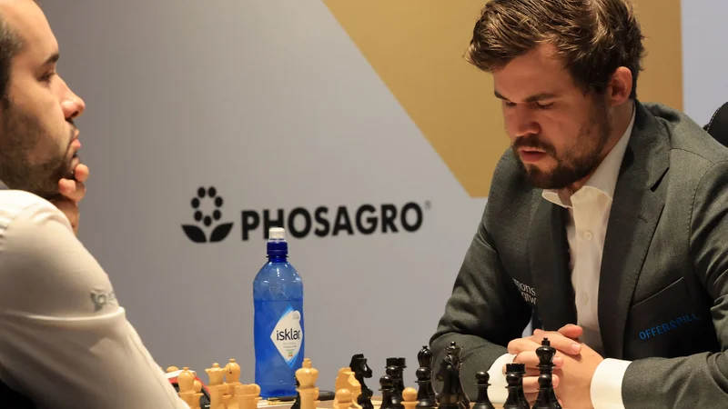 Fotografija: Magnus Carlsen (desno) in njegov ruski tekmec med peto partijo v Dubaju. FOTO: Giuseppe Cacace/AFP