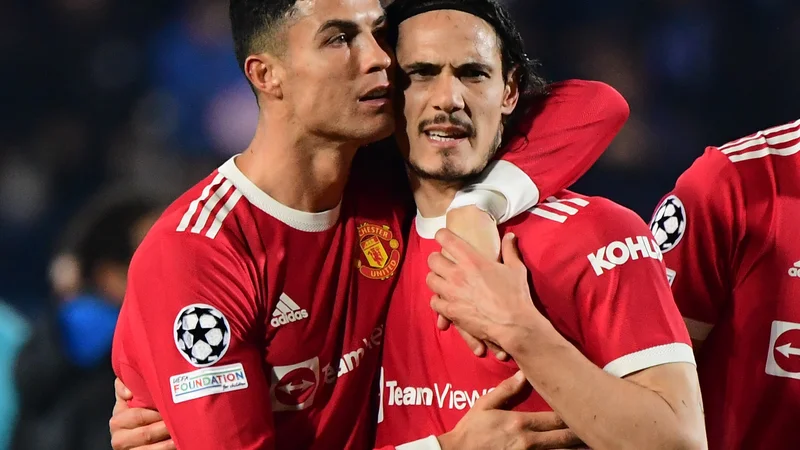 Fotografija: Edinson Cavani (desno) ob Cristianu Ronaldu. Povratek Portugalca k Unitedu je Urugvajčeve minute na igrišču še dodatno omejil. FOTO: Alberto Lingria/Reuters