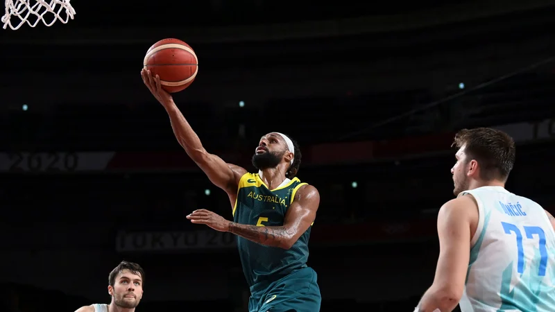 Fotografija: Patty Mills (z žogo) je bil v Saitami nerešljiva uganka za slovenske košarkarje na čelu z enim najboljših posameznikov turnirja Luko Dončićem. FOTO: Aris Messinis/AFP
