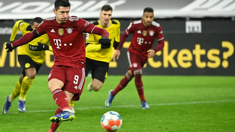 Fotografija: Robert Lewandowski je v 77. minuti odločil nemški derbi z uspešno izvedeno enajstmetrovko. FOTO: Ina Fassbender/AFP