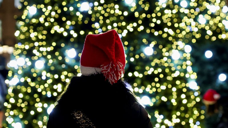 Fotografija: A woman with a Christmas hat stands near Christmas trees installed on the Place Vendome as part of the holiday season illuminations in Paris, France, December 8, 2021. REUTERS/Sarah Meyssonnier Foto Sarah Meyssonnier Reuters
