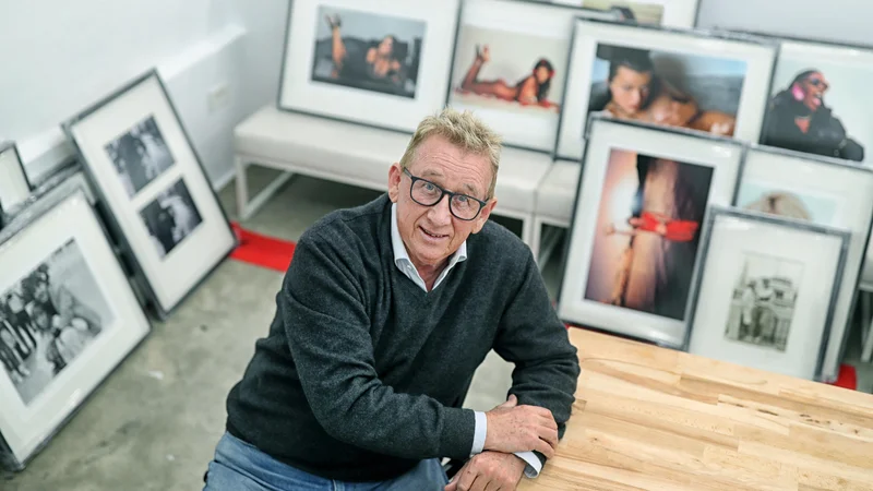 Fotografija: Jadran Lazić pred svojim življenjskim delom. Na eni od fotografij je Milla Jovovich, ki mu je pozirala gola. FOTO: Blaž Samec/Delo