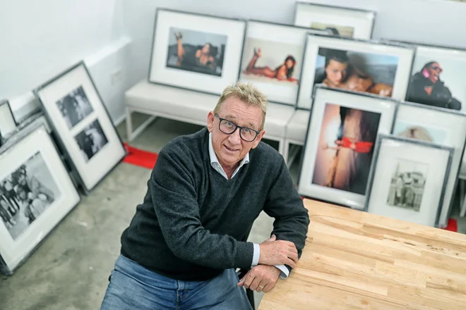 Jadran Lazić pred svojim življenjskim delom. Na eni od fotografij je Milla Jovovich, ki mu je pozirala gola. FOTO: Blaž Samec/Delo
