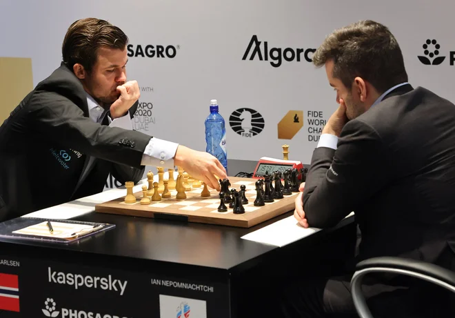 Magnus Carlsen (levo)&nbsp;je pri 31 letih starosti osvojil svoj peti naslov svetovnega prvaka. FOTO: Giuseppe Cacace/AFP
