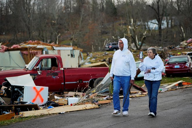 Zakonca Bill in Bonnie Mosley si ogledujeta razdejanje po tornadu z orožjem v roki, edinima predmetoma, ki sta ju uspela rešiti iz uničenega doma. FOTO: Cheney Orr/Reuters
