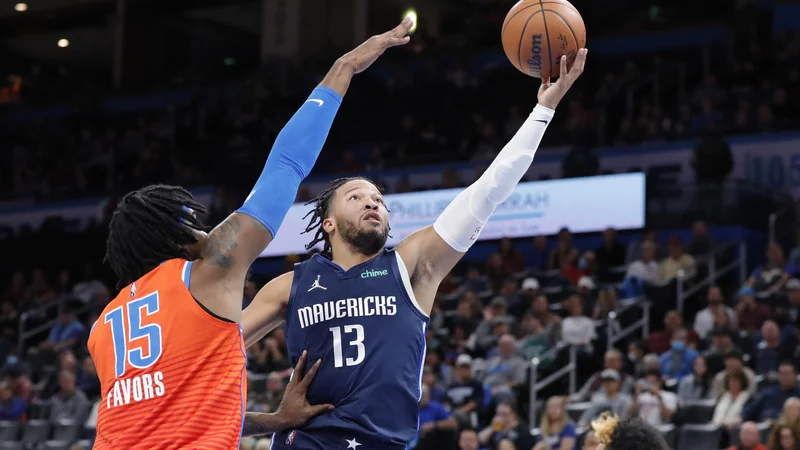 Fotografija: Jalen Brunson (z žogo) prodira pod koš ob centru domače ekipe Derricku Favorsu v dvorani Paycom Center. FOTO: Alonzo Adams/USA Today Sports
