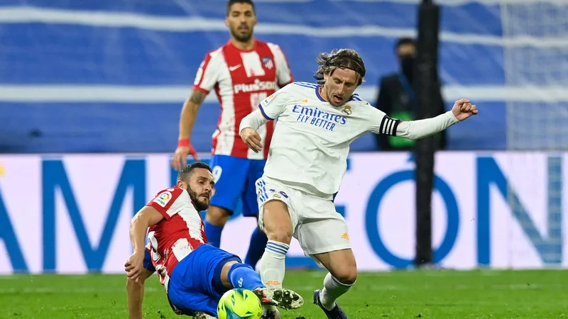 Fotografija: Dvoboj kapetanov Kokeja in Luke Modrića (desno) med zadnjim madridskim derbijem na štadionu Santiago Bernabeu. FOTO: Oscar Del Pozo/AFP