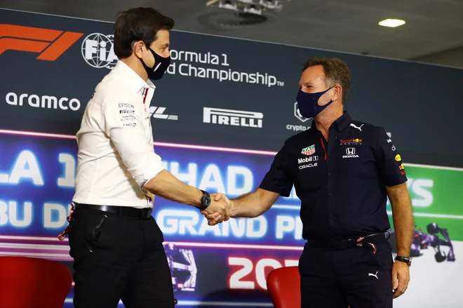 Šefa ekip Toto Wolff (levo) in Christian Horner med pozdravom ob začetku petkove novinarske konference v Abu Dabiju. FOTO: Reuters
