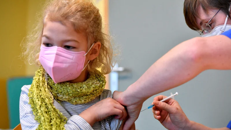 Sedemletnica na cepljenju v Nemčiji. FOTO: Matthias Rietschel/ Reuters
