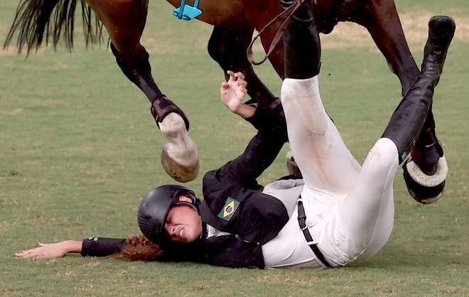 Avgust 2021. Utrinek iz modernega peteroboja v okviru ženskega jahanja na OI v Tokiu, ko je Brazilka Ieda Guimaraes med tekmovanjem padla s konja. FOTO: Ivan Alvarado/Reuters

 
