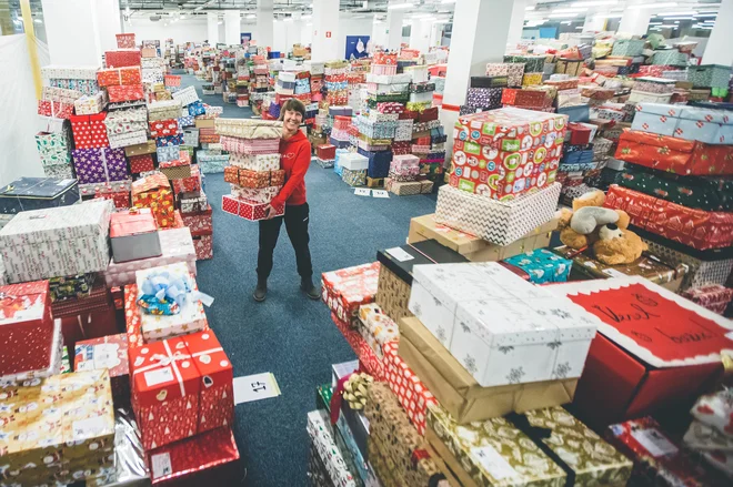 Božiček za en dan že osmo leto gostuje v BTC. Za njim stoji Savina Goličnik, ki ravno tako potrebuje lepo četico škratov, da ga vsak december izpeljejo. FOTO: Grega Valančič
