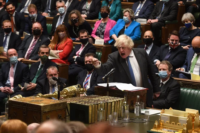 Britanski premier Boris Johnson gestikulira med premierskimi vprašanji v parlamentu v Londonu, kjer je v sredo branil napade o svoji sposobnosti za vodenje, potem ko se je skoraj 100 njegovih poslancev uprlo njegovim novim omejitvam zaradi koronavirusa. FOTO: Talor Affsica/Afp
