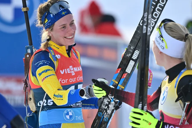 Marte Olsbu Roeiseland (desno) pozdravlja Elviro Öberg po decembrski zasledovalni preizkušnji v avstrijskem Hochfilznu. FOTO: Joe Klamar/AFP