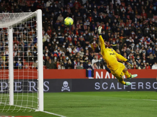 Jan Oblak ni uspel ustaviti izstrelka hrvaškega vezista v Sevilli. FOTO: Marcelo del Pozo/Reuters
