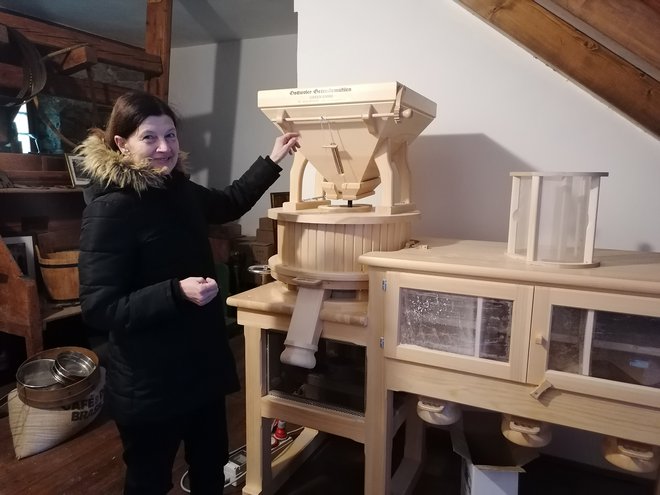 Eva Bordon ob novem električnem mlinu, ki – enako kot stari – melje žito s pomočjo mlinskih kamnov. FOTO: Nataša Čepar
