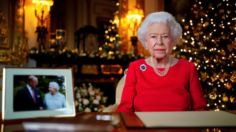 Fotografija: Kraljica je bila oblečena v rdečo obleko z biseri okoli vratu, na obleki je imela broško s safirjem, ki jo je nosila na poročnem potovanju ter kasneje na diamantni poroki. FOTO: Victoria Jones/Pool/Reuters
