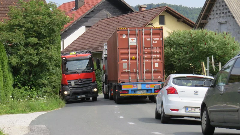 Fotografija: Med stanovanjskimi hišami v Zgornjem Hotiču je srečevanje dveh tovornih vozil že desetletja oteženo. FOTO: Bojan Rajšek/Delo