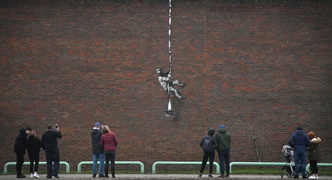 Grafit na zidu nekdanje kaznilnice v Readingu. Država jo prodaja, čeprav je bil v njej zaprt tudi Oscar Wilde. FOTO: Ben Stansall/AFP
