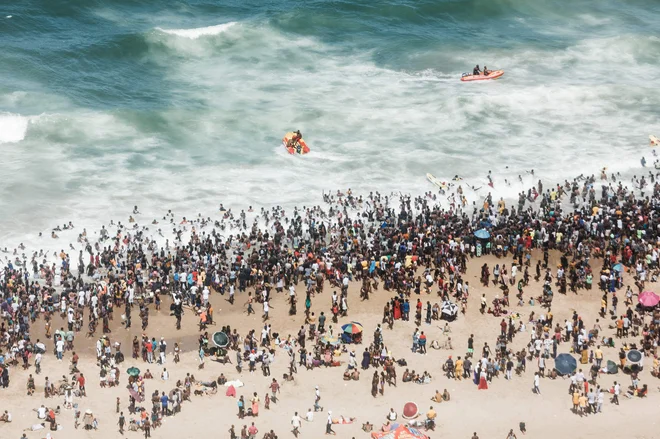 Na tisoče Južoafričanov se je zbralo na plaži North Pier Beach v Durbanu, potem ko je vlada odpravila policijsko uro, ki je trajala od polnoči do četrte ure zjutraj. Po podatkih policije naj bi skoraj 50.000 ljudi preživelo nedeljo na tej plaži. FOTO: Rajesh Jantilal/AFP
