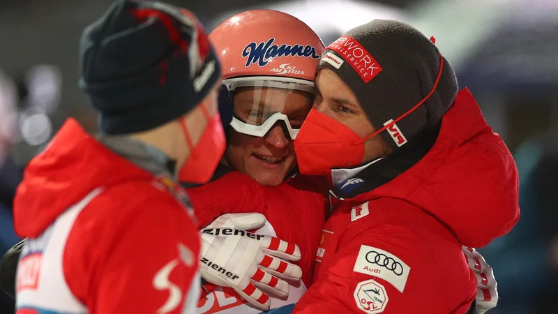 Fotografija: Avstrijci imajo novega skakalnega junaka: Daniel Huber proslavlja v objemu kolegov iz reprezentance. FOTO: Lisi Niesner/Reuters